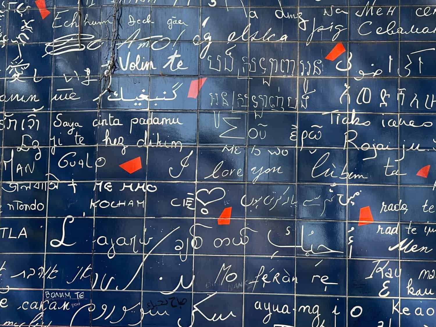 Close-up of 'I love you' written in various languages on the Wall of Love in Paris.
