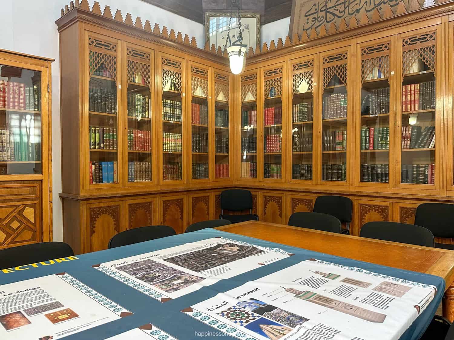 Interior of the Paris Grand Mosque library with wooden bookshelves and numerous books.