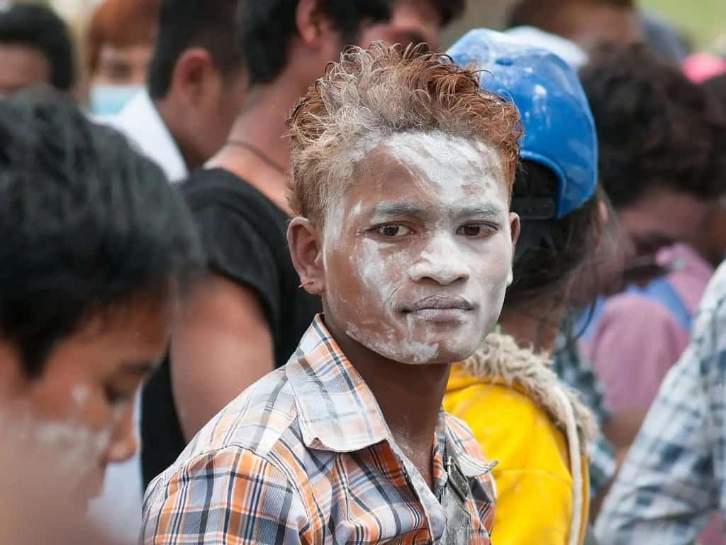 oyful children and teenagers engaging in traditional baby powder (talcum powder) and flour games, celebrating the playful spirit of Cambodian New Year 2024.