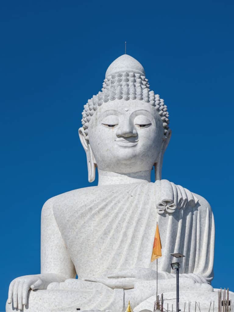 Dramatic angle of the Big Buddha Phuket against the clear blue sky.