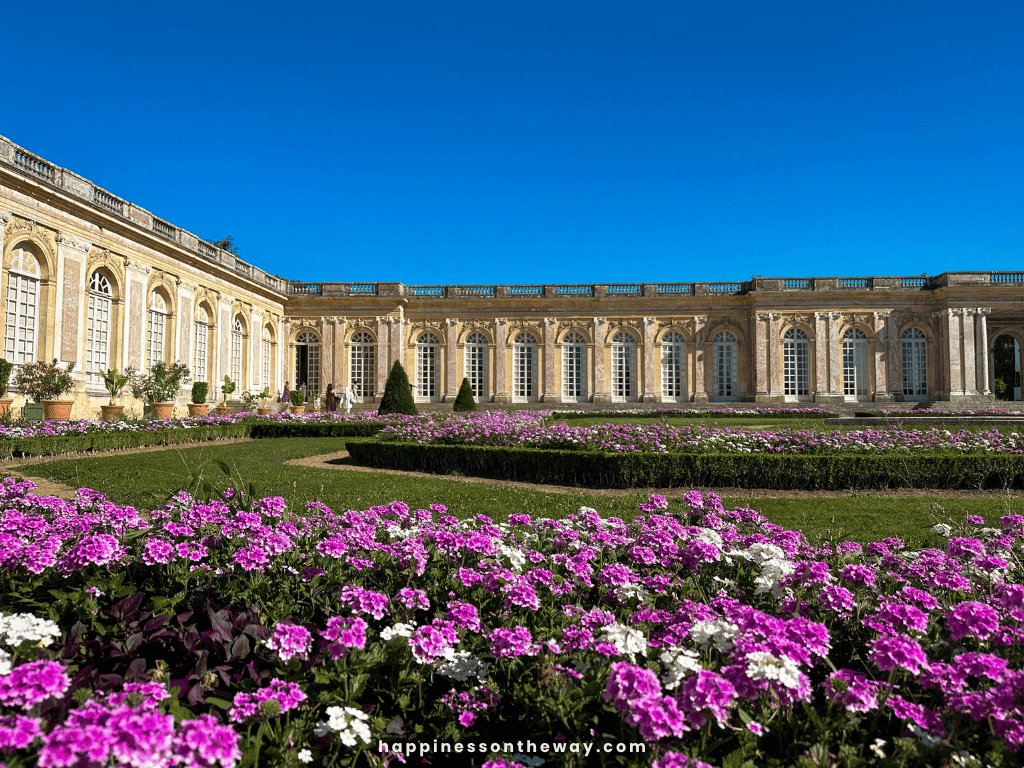 Grand Trianon with its pink and yellow facade and a garden 