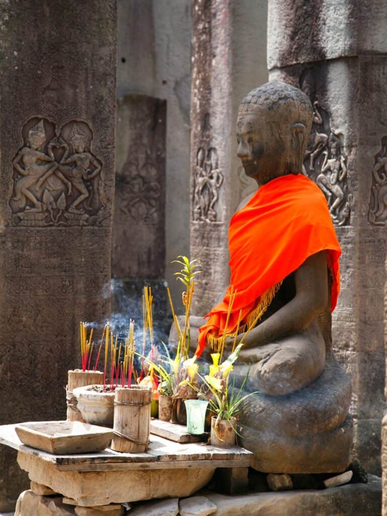 Devotees presenting traditional offerings to Buddha at Angkor Wat, marking the Cambodian New Year 2024 with a focus on spiritual blessings and cultural heritage.