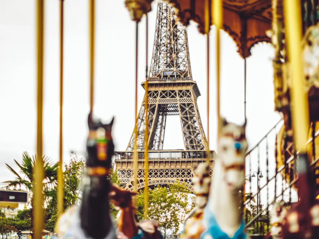 The Eiffel Tower captured through the blurred movement of a carousel, creating a whimsical and nostalgic perspective of this iconic Parisian landmark