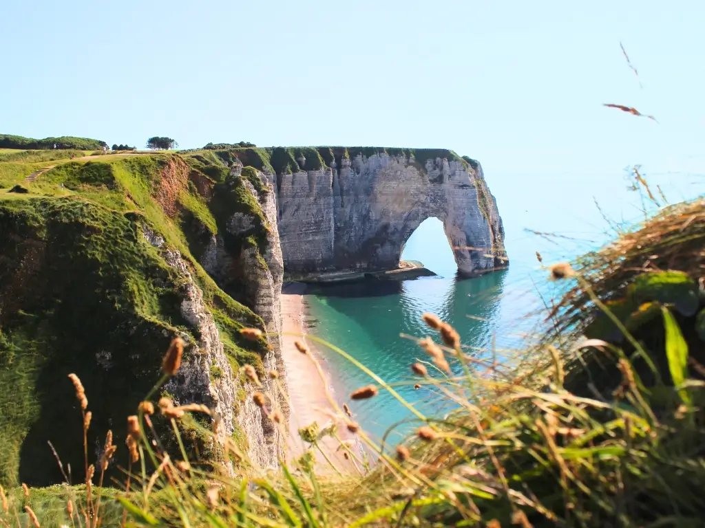 View of the 'Elephant Cliff' in Étretat, a natural arch that looks like an elephant's trunk reaching into the sea. A popular natural attraction for a relaxing day trip from Paris by train.