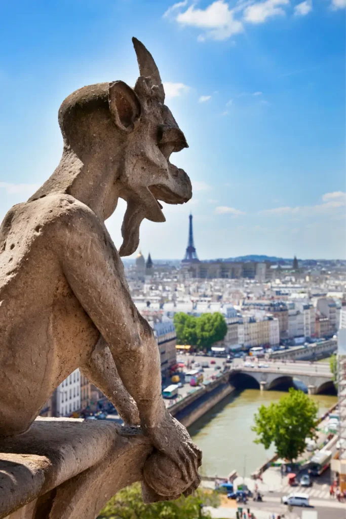 A Chimera statue from Cathédrale Notre-Dame de Paris overlooks the city, with one of the best views of the Eiffel Tower in the distance, the Seine River, and Parisian streets below.