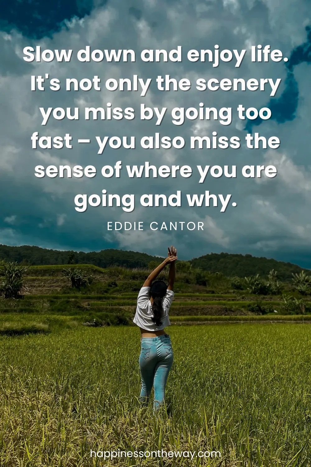 A person stands with raised arms amidst a lush green rice field under a dynamic sky, with the quote 'Slow down and enjoy life. It's not only the scenery you miss by going too fast – you also miss the sense of where you are going and why.' by Eddie Cantor
