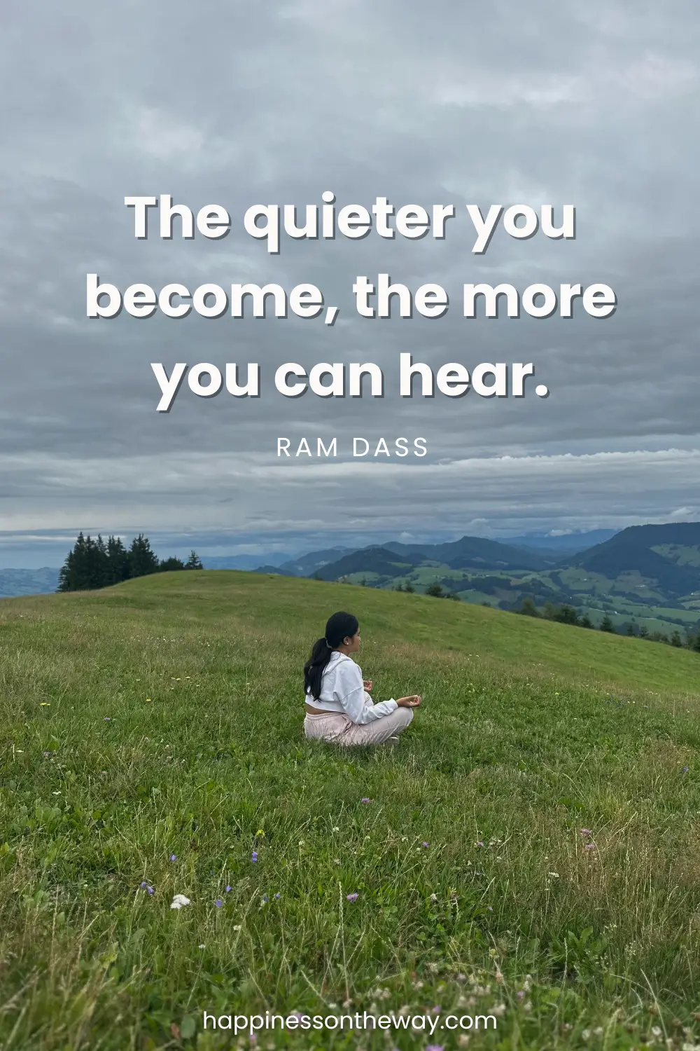Me meditating in a serene grassy field with distant hills, paired with the quote 'The quieter you become, the more you can hear.' by Ram Dass