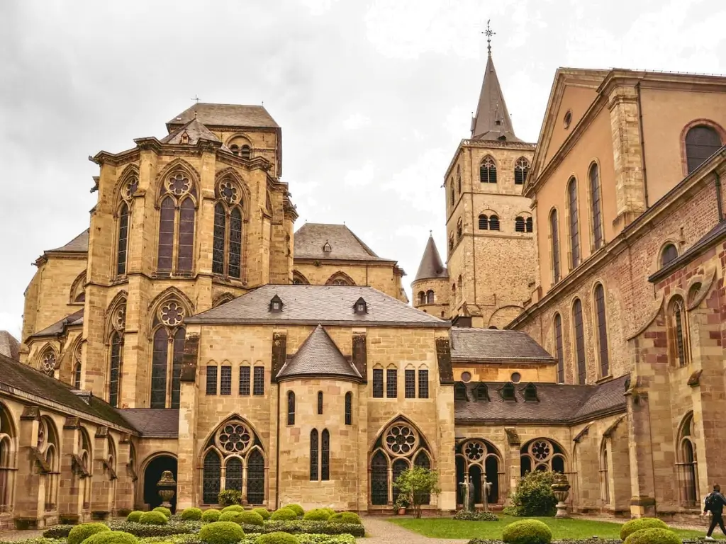 Exterior view of the ancient Trier Cathedral in Germany with its Romanesque architecture and a neatly kept courtyard. Trier Germany is off-the-beaten-path destination for the best day trips from Paris by train to other countries