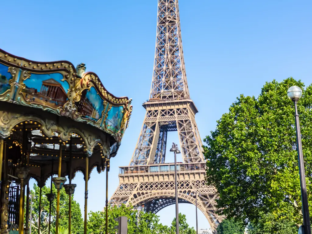 The Eiffel Tower standing tall and clear in the background, with the ornate details of a vintage carousel on the right, in a scene that blends Parisian charm and history.