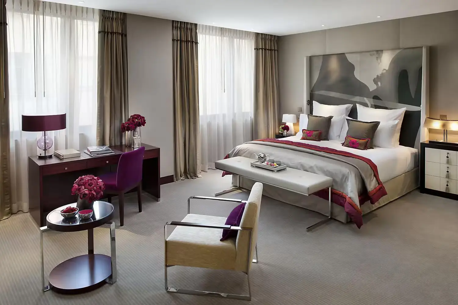 Modern and chic bedroom at the Mandarin Oriental, a green hotel in Paris, showcasing a blend of comfort and style with a plush bed, contemporary furniture, and accents of vibrant purple.
