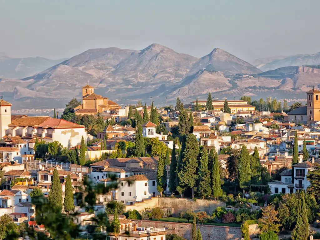 Panoramic view of Granada's historic cityscape with the Sierra Nevada in the backdrop in Spain, a cultural gem among slow travel destinations.