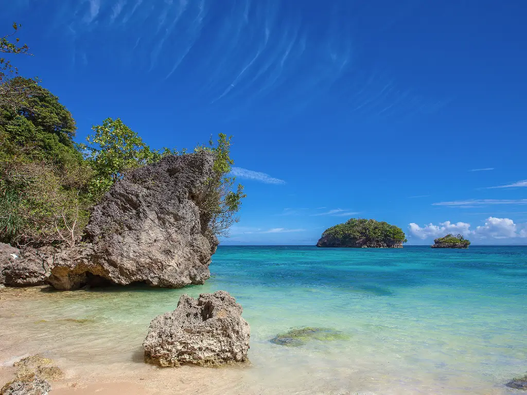 Serene view of Ilig-iligan Beach, also known as Newcoast Beach, featuring clear turquoise waters and lush greenery, included in Boracay land tour itinerary.