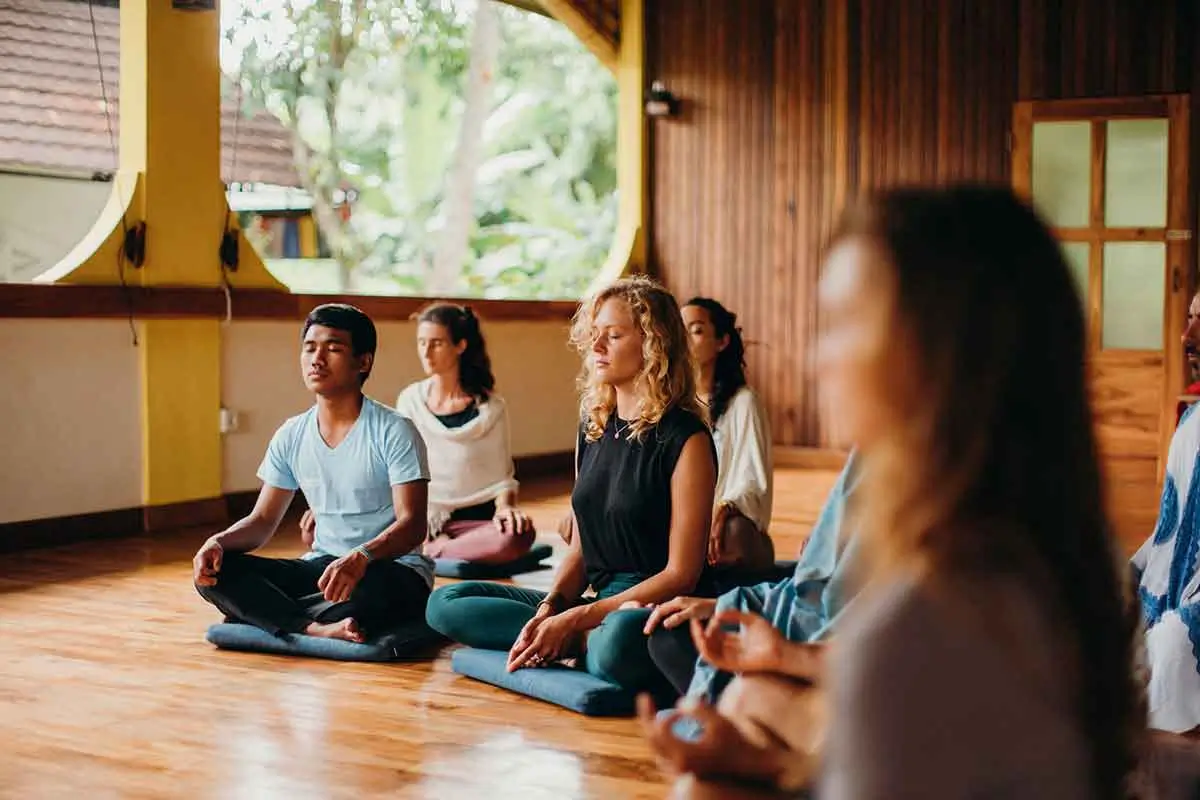 indfulness meditation session with diverse individuals at a silent meditation retreat, embodying the tranquility offered by wellness retreats in Bali.