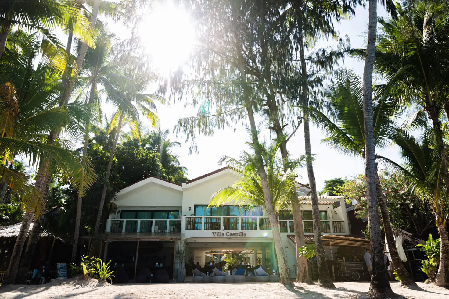 Villa Caemilla is one of Boracay's best boutique hotels, with palm trees surrounding the white building. The hotel fronts directly onto the beach, offering easy access to the sandy shore.