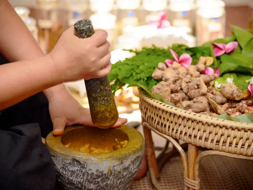 Grinding turmeric during an ayurvedic cooking class