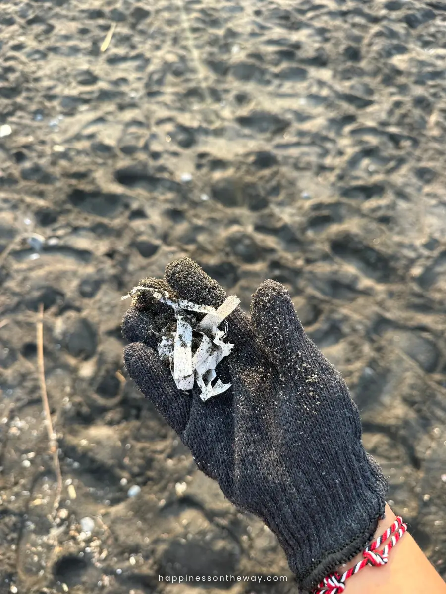 My hand with gloves with some plastic on a beach cleanup in Bali