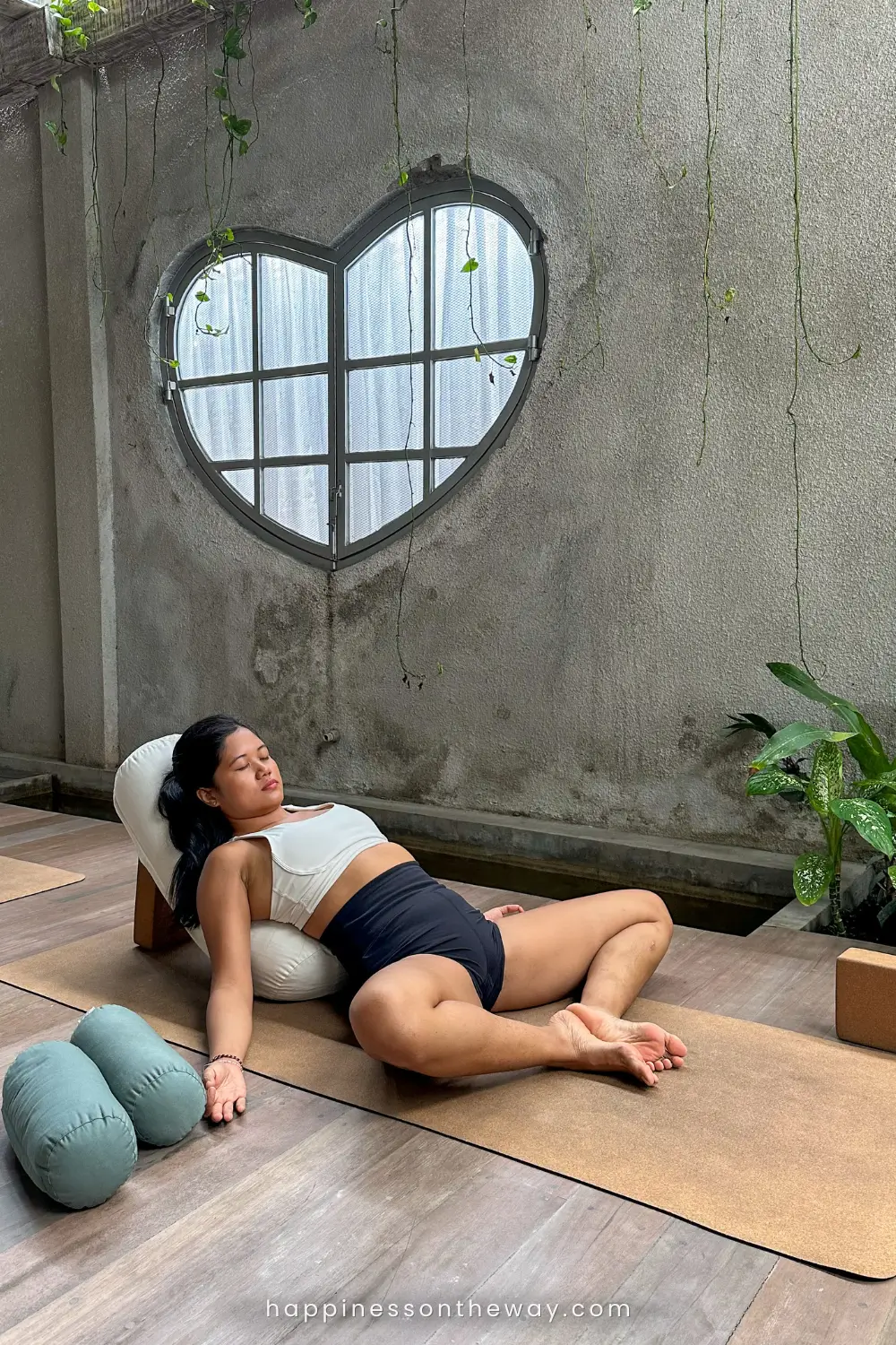 Me on a yoga attire lying on pillows on a butterfly position for a yin yoga in Ubud