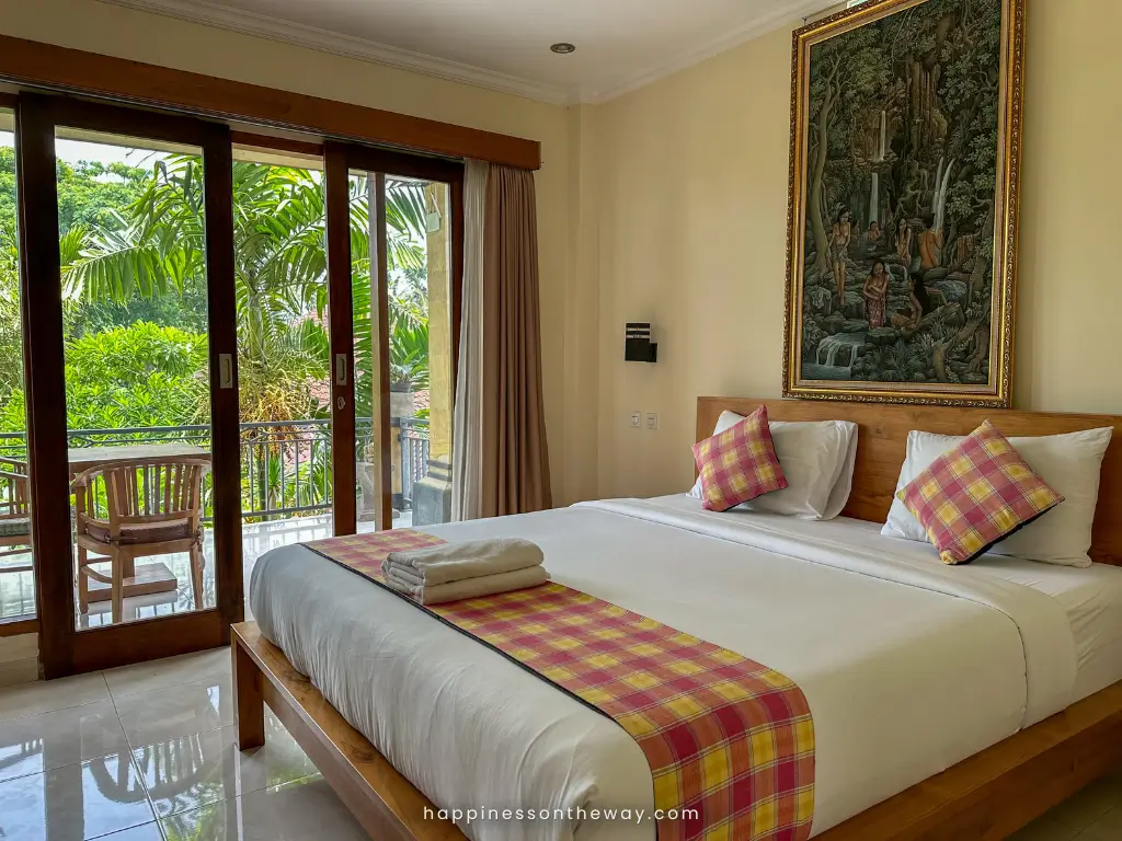 A queen size bed inside our room with a garden terrace in Yudha Ubud