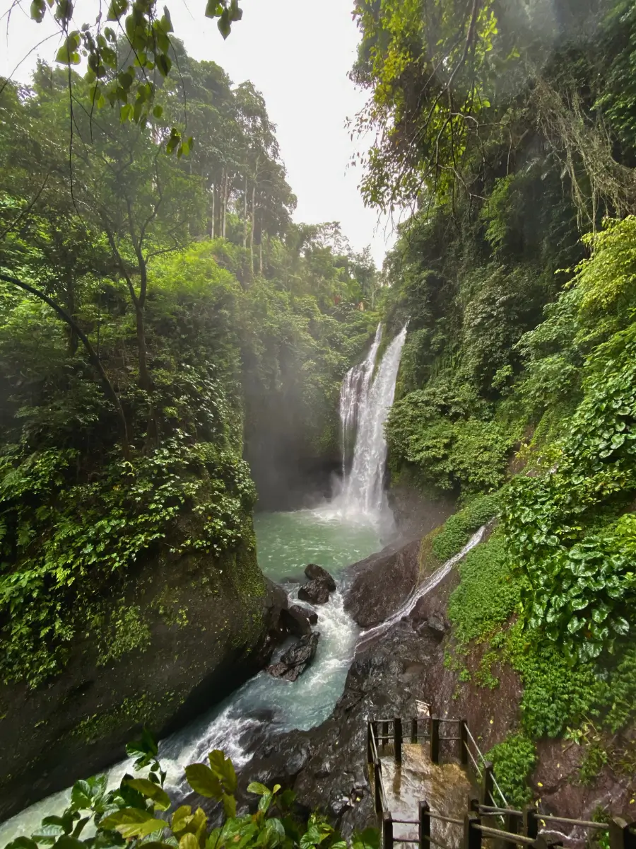 Aling Aling waterfall flowing in a deep pool inside a tropical forest.