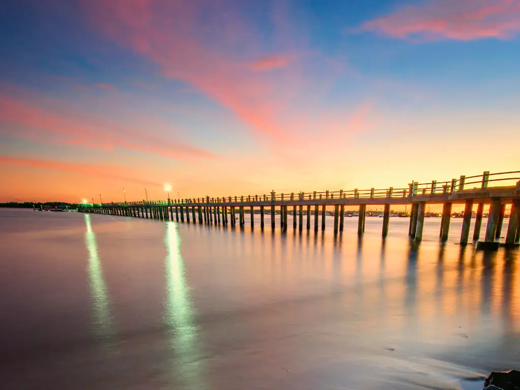 A wooden walkway bridge at Mertasari Beach harbor