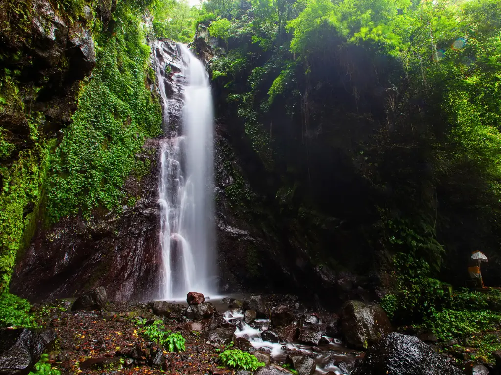 Yeh Mampeh Waterfall flowing into rocks in a tropical forest.