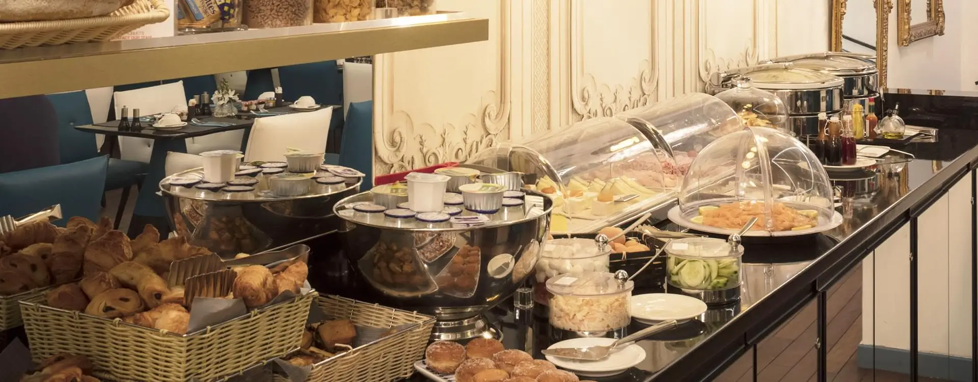 A delightful breakfast spread at Hôtel Malte in Paris, featuring an array of cheeses, fresh bread, and other morning delicacies.