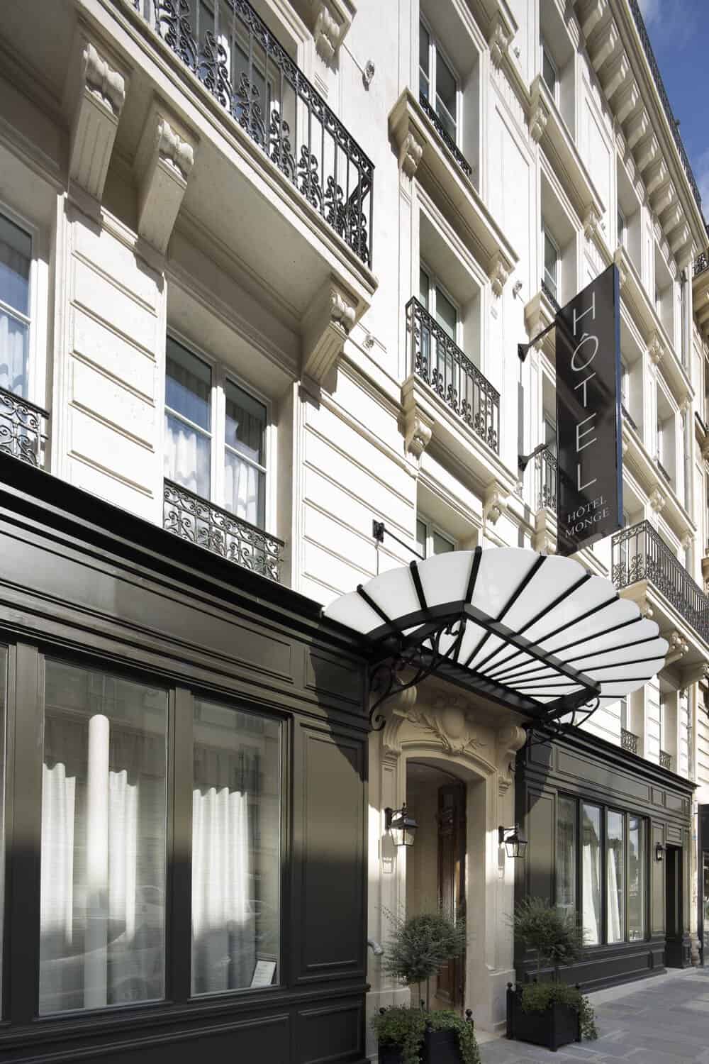 The entrance facade of Hotel Monge in Paris features cream and white tones, reflecting the calm and sophisticated atmosphere of this quiet hotel in the heart of the city.