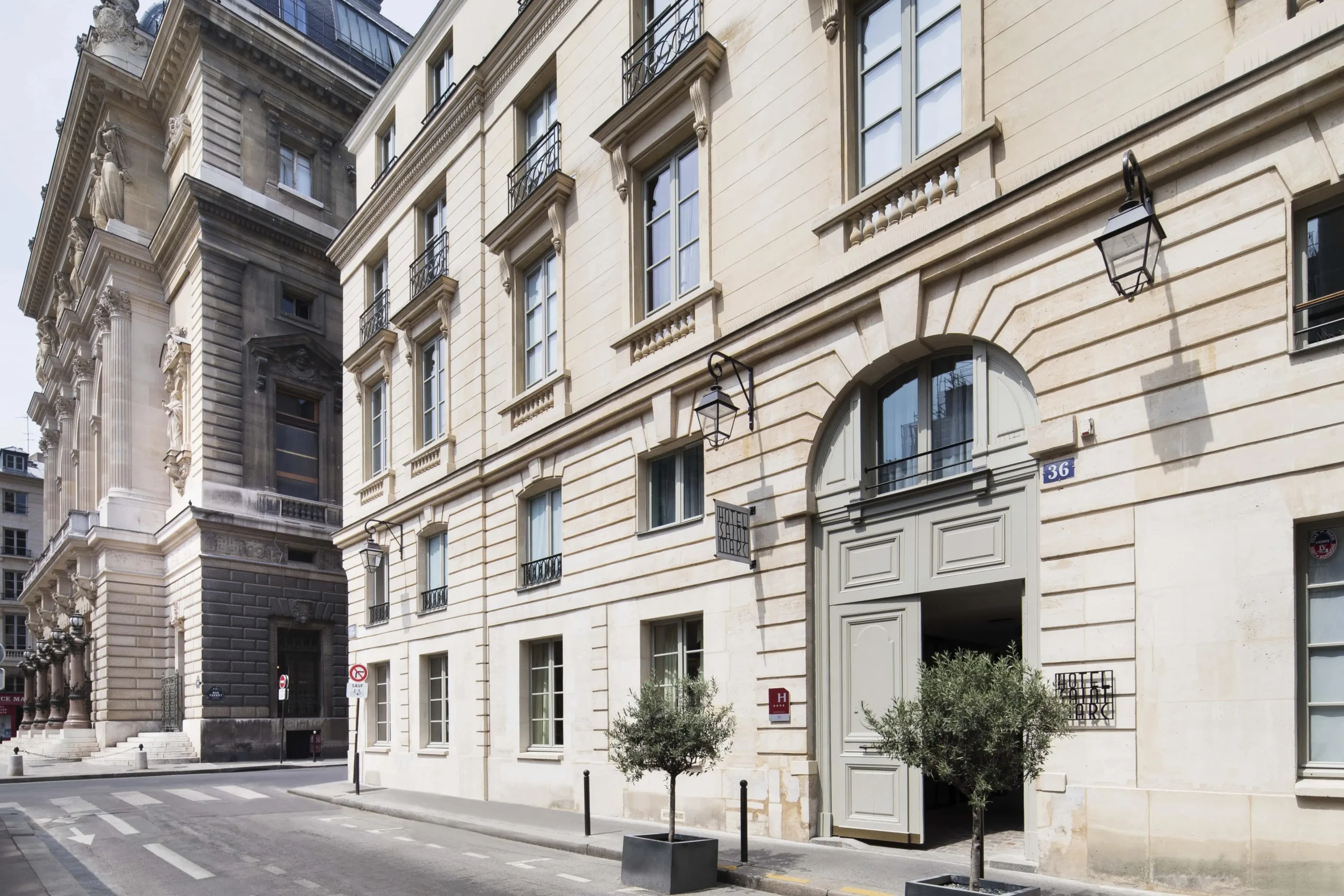 The cream-colored facade of Hotel Saint-Marc in Paris, a quiet retreat in the heart of the city, exudes elegance with its classic architectural details and charming windows.