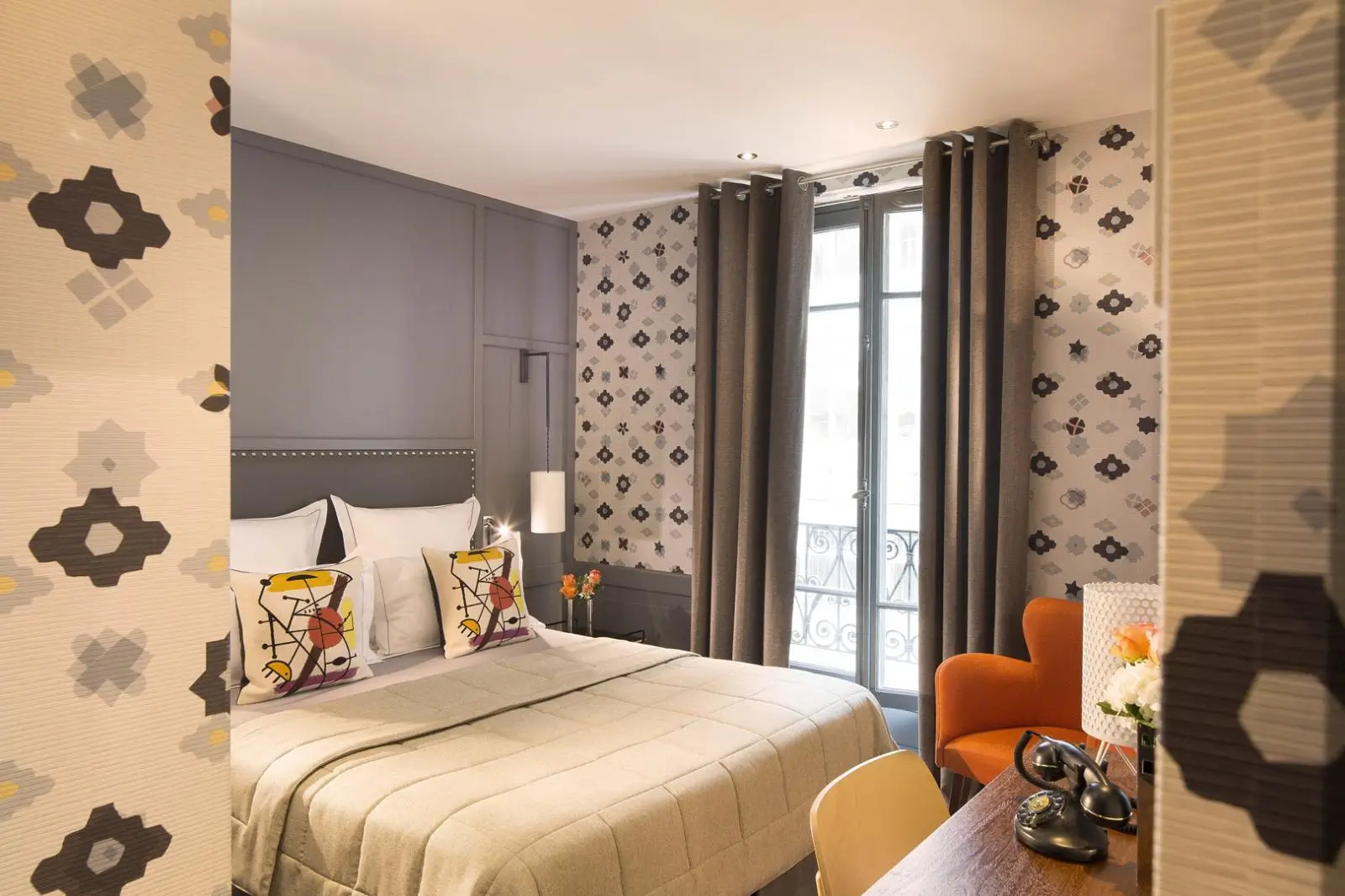 A cozy room at Hôtel Signature Saint Germain des Prés, a quiet hotel in Paris, featuring a warm brown and yellow color palette, plush bedding, and soft lighting.