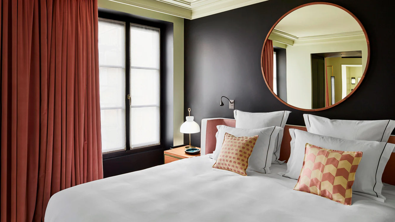 A serene and elegant bedroom at Le Roch Hotel & Spa in Paris, featuring soft lighting, plush bedding, and modern decor.