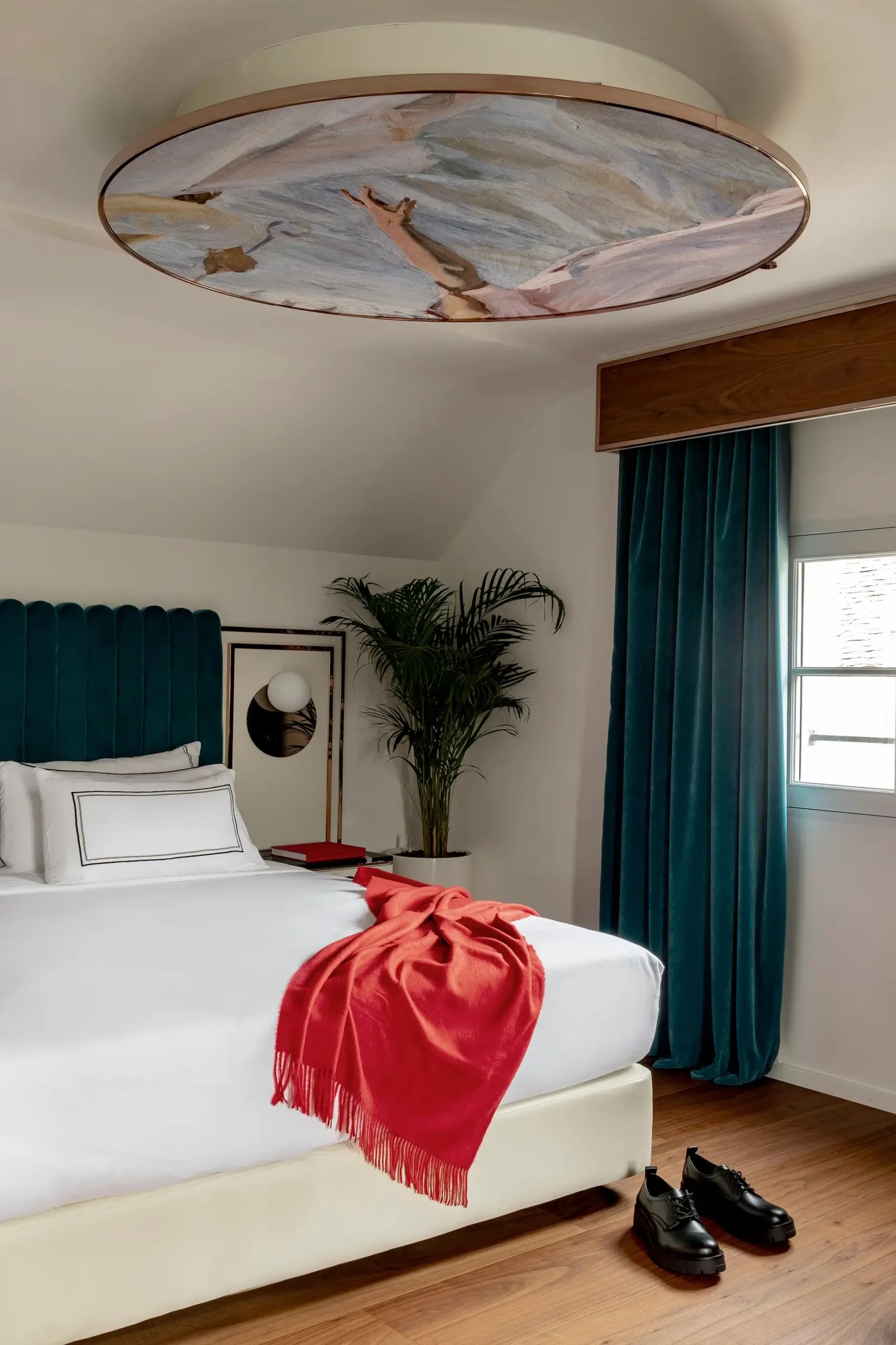 Elegant bedroom with white sheets and soft lighting and classic decor at Maison Colbert Meliá Collection, Paris.