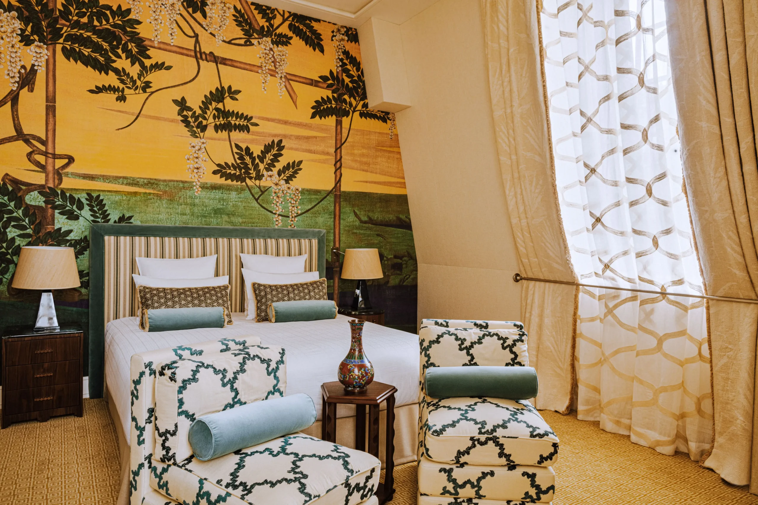 Elegant and quiet hotel room at the Saint James Paris with a luxurious bed, botanical mural, and plush seating. Perfect for travelers searching for peaceful hotels in Paris.