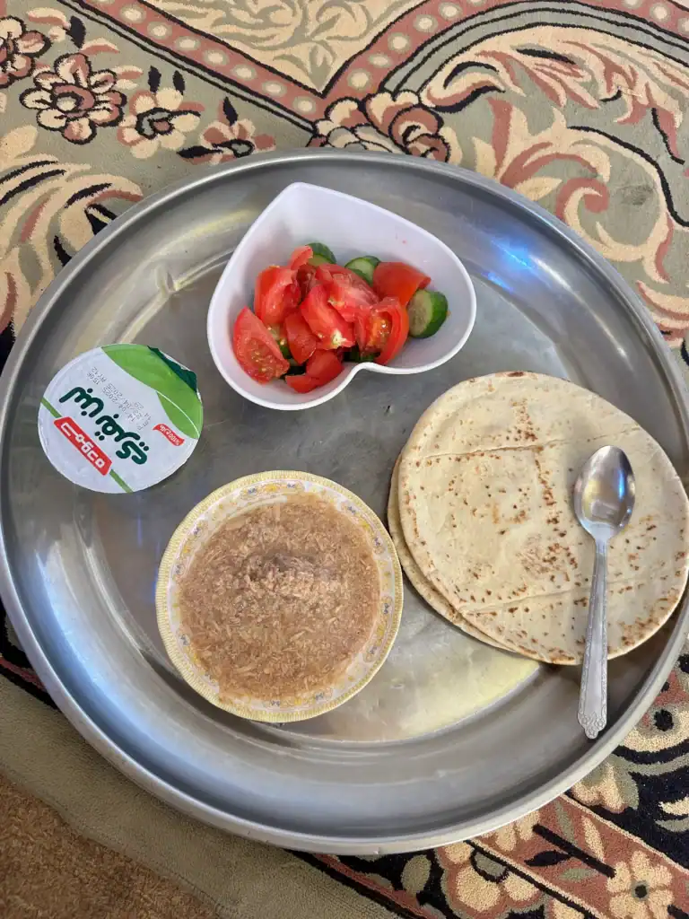 A traditional Jordanian meal served on a tray with soup, pita bread, yogurt, and fresh salad—part of a volunteer homestay experience