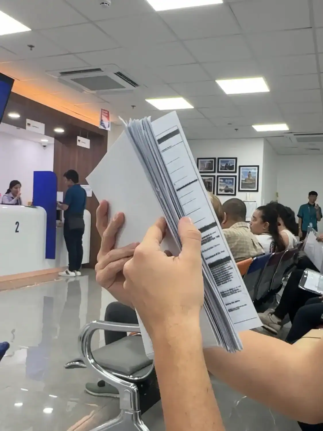 A thick stack of visa requirements while waiting in line at visa application center.