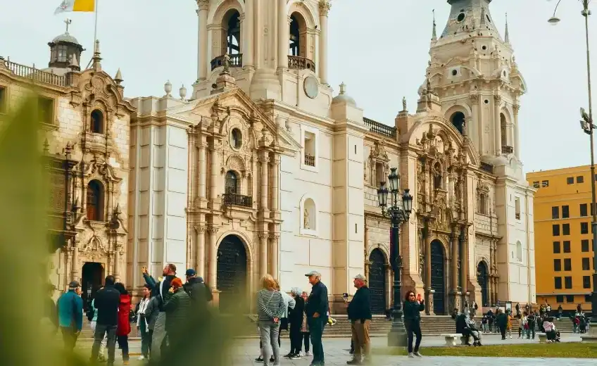 Tourists gather outside the grand, baroque-style façade of the Cathedral of Lima in Peru’s Plaza Mayor.