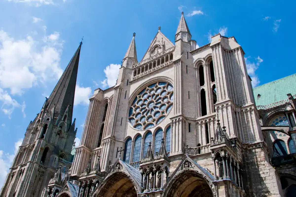 Facade of Chartres Cathedral with intricate Gothic architecture under a bright blue sky in France