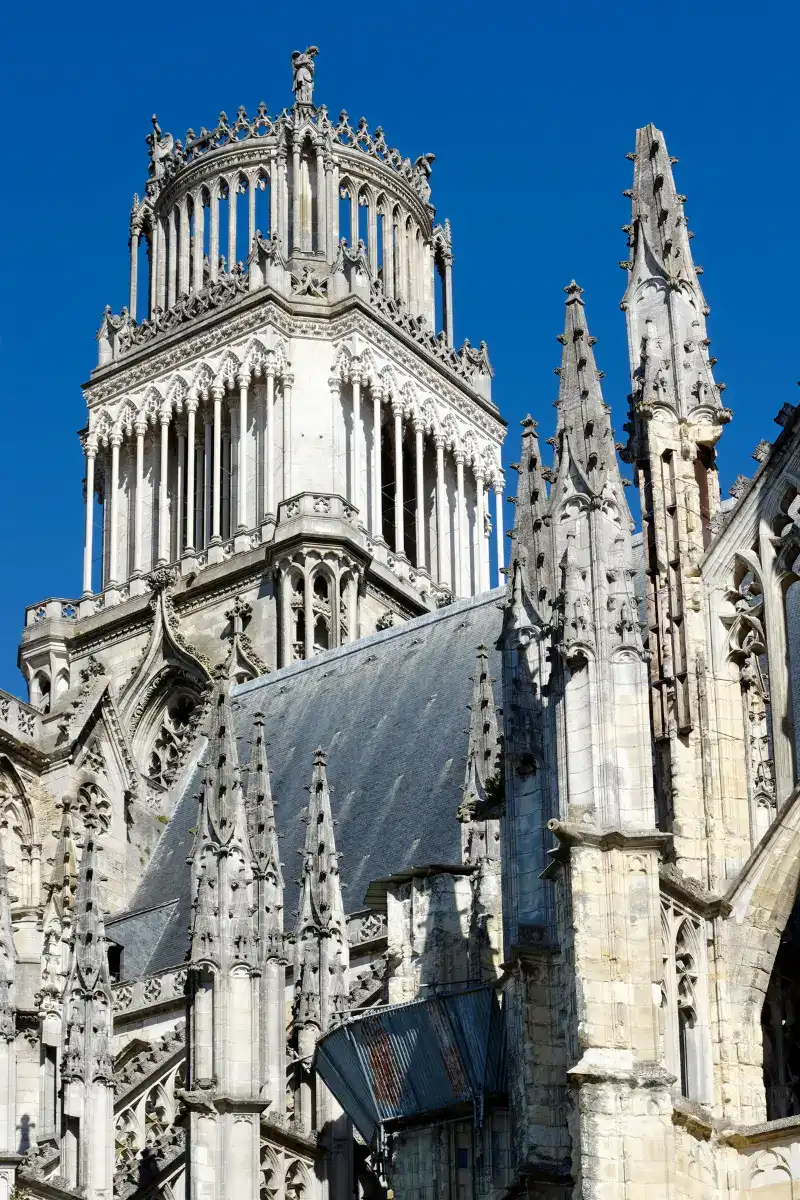 Detailed view of the ornate spire and Gothic tower of Orléans Cathedral against a clear blue sky