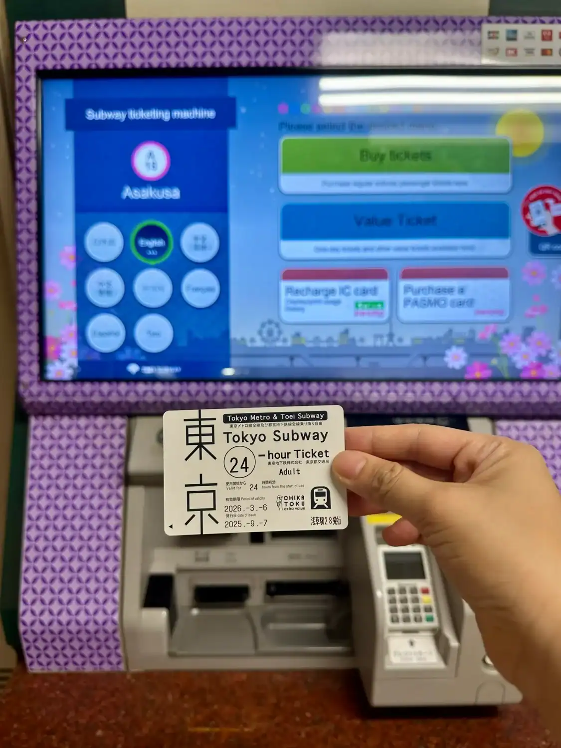 Tokyo Subway 24-hour Ticket held in front of the ticketing machine screen at Asakusa Station. Contemplating, Is the Tokyo Metro Pass Worth it