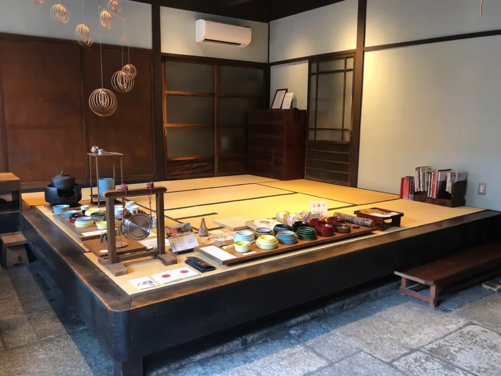 Traditional tatami tea room in Kyoto prepared for a matcha ceremony, with tea bowls and utensils arranged neatly on a low platform.