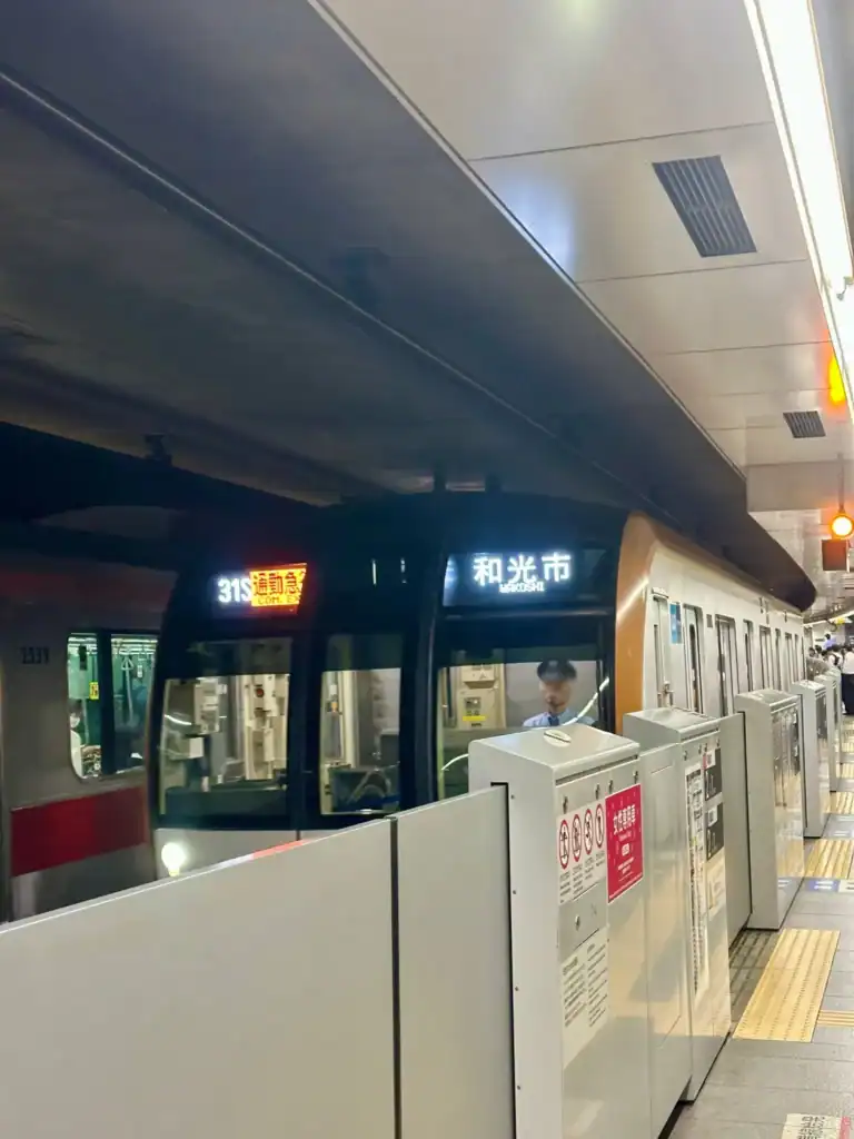 okyo subway train arriving at the platform with signage showing destination Wakoshi