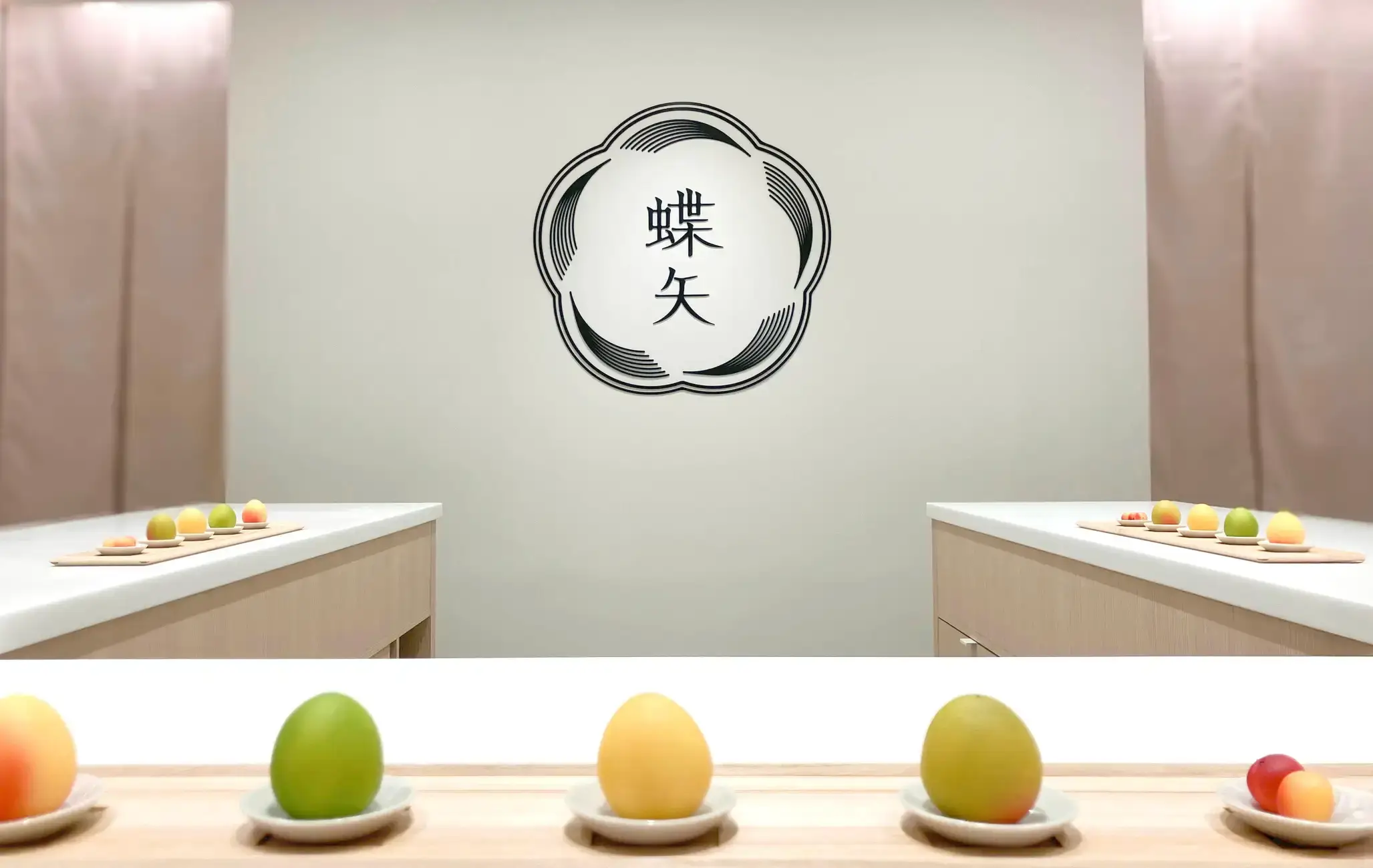 Colorful ume plums displayed on small plates inside a clean workshop space, ready for making umeshu and ume syrup.