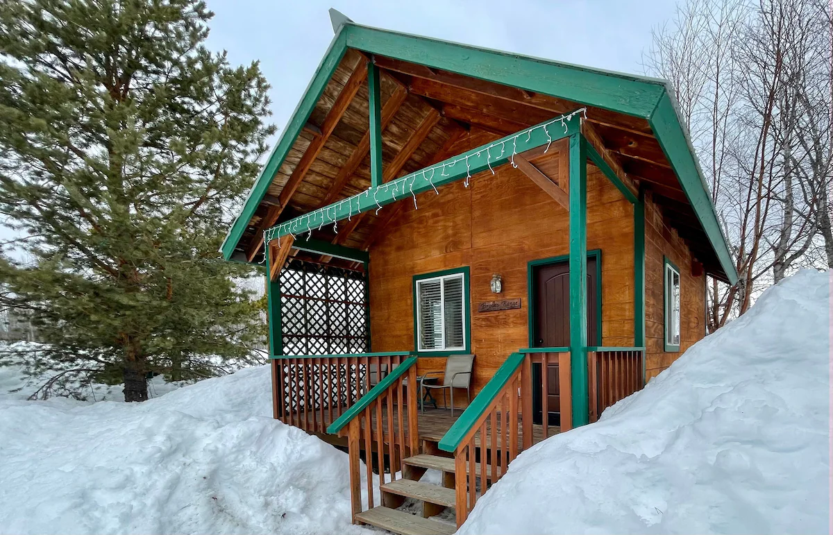 The snow-covered wooden exterior of Chinook Wind Cabins, another well-known place to stay in Talkeetna.