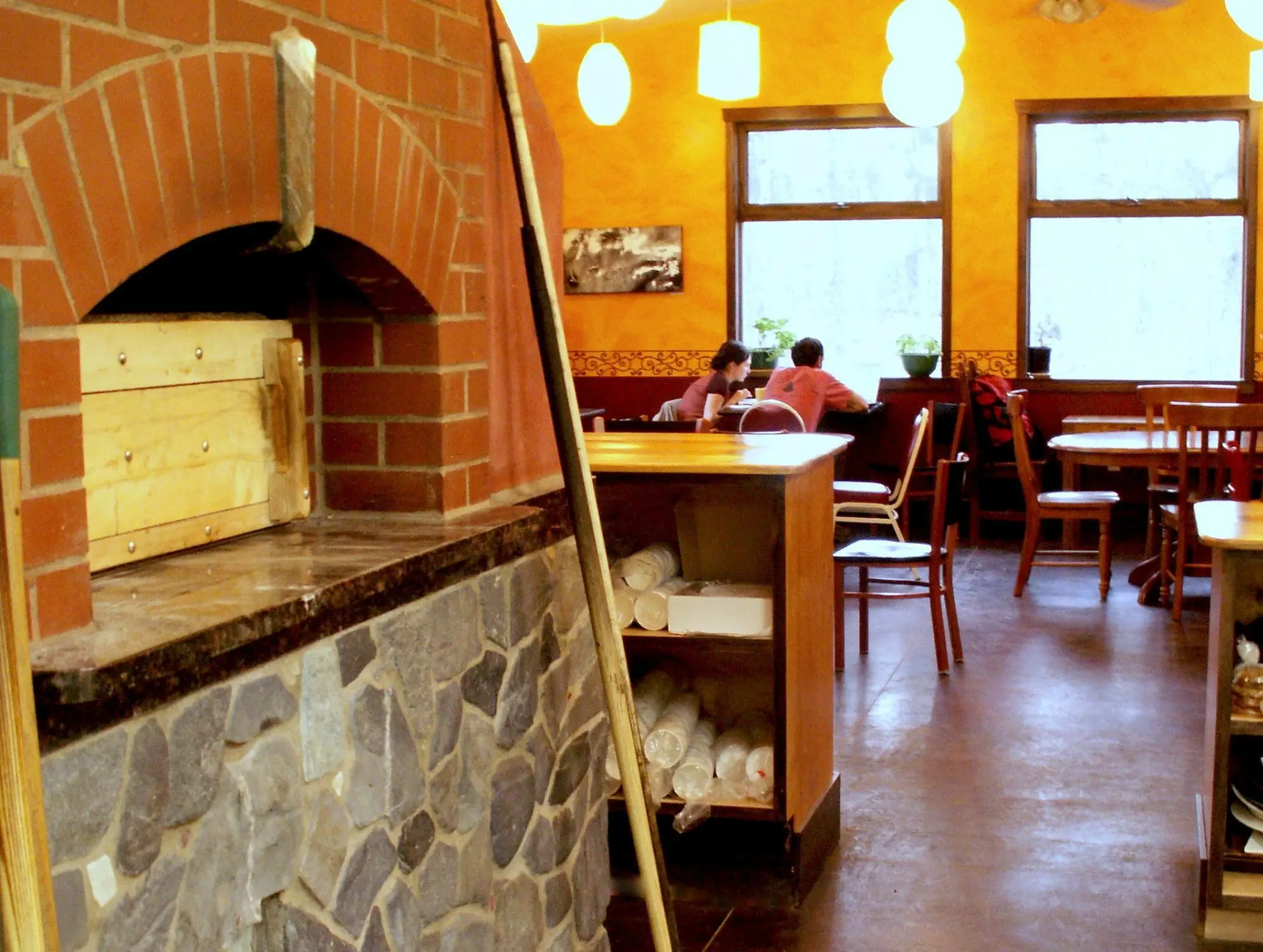 An image of the brick oven, orange walls, and large windows of Flying Squirrel Bakery & Cafe, where travelers can find some of the best food in Talkeetna.