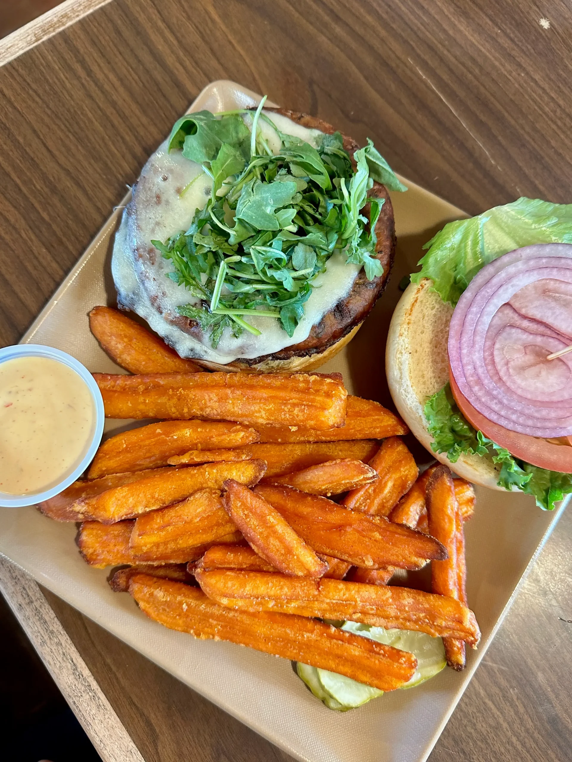 Open-faced reindeer burger with onions and lettuce, served with golden sweet potato fries and mustard sauce at Talkeetna Roadhouse.