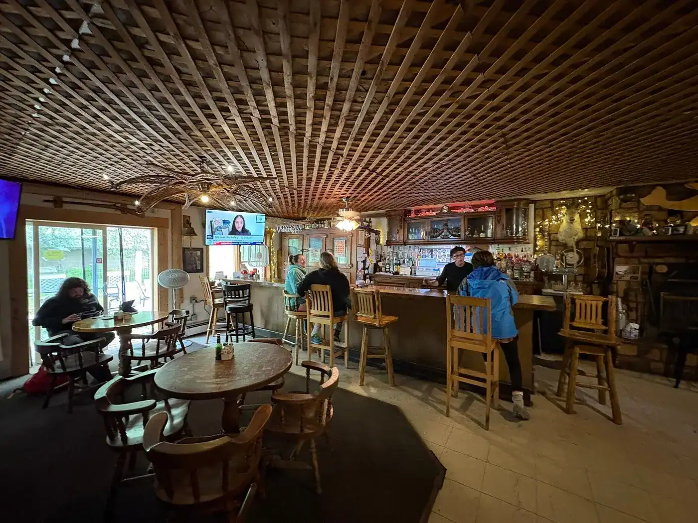Guests at the rounded tables, countertop seats, and bar of Latitude, one of the many beloved restaurants in Talkeetna.