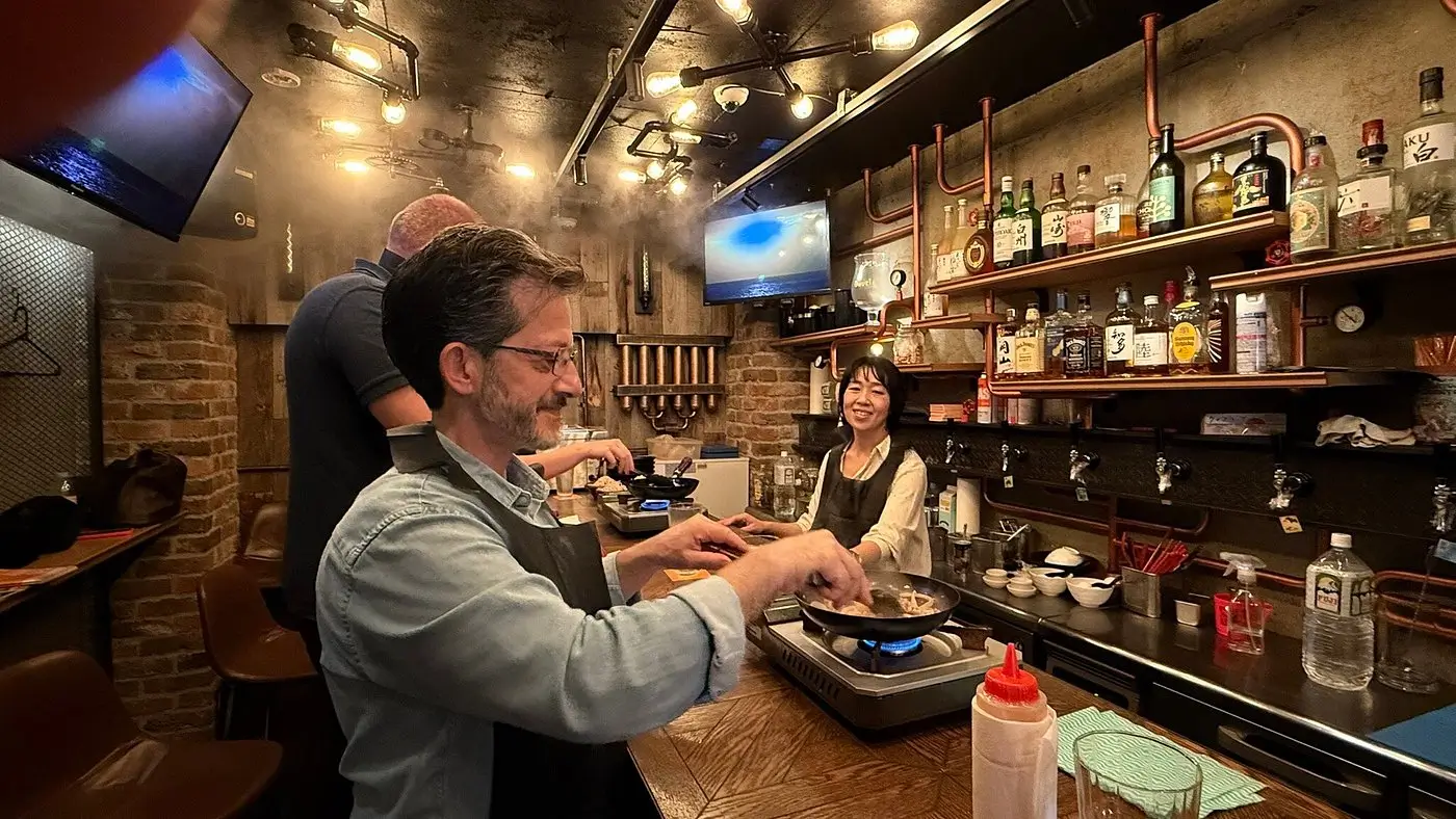 Relaxed people enjoying cooking together at a Japanese-inspired bar or restaurant.