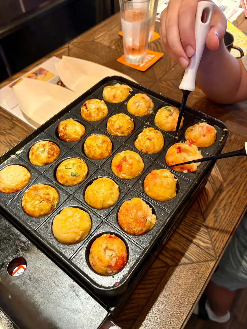 Takoyaki making with golden-brown octopus balls.