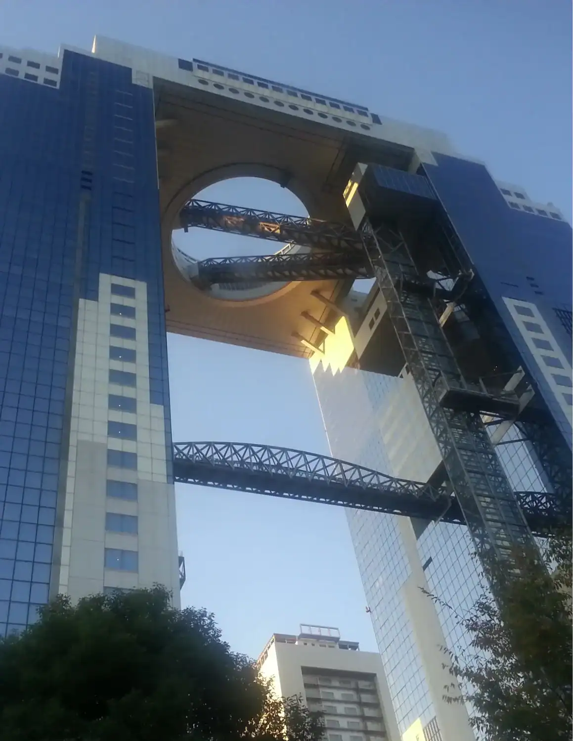 The Umeda Sky Building in Osaka viewed from below, showing its two connected towers and circular open-air observatory.