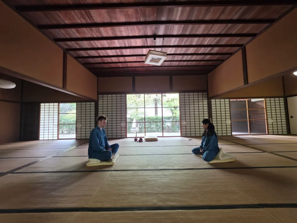 Two people sitting on cushions during a quiet Zen session inside a tatami room at Manpukuji Temple in Uji.