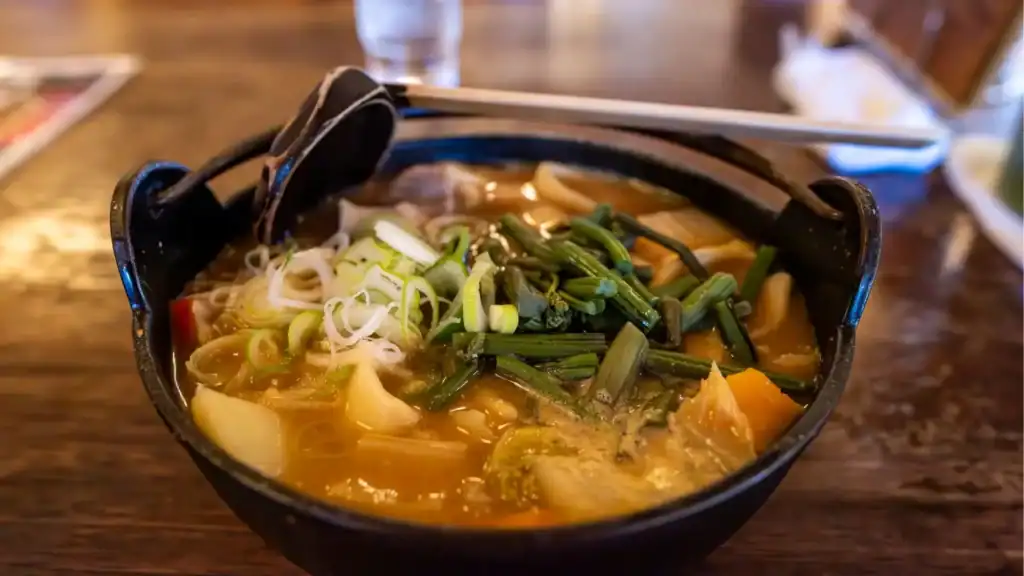 Bowl of hōtō noodles in miso broth with vegetables, a comforting Japanese dish from the Mt. Fuji region.